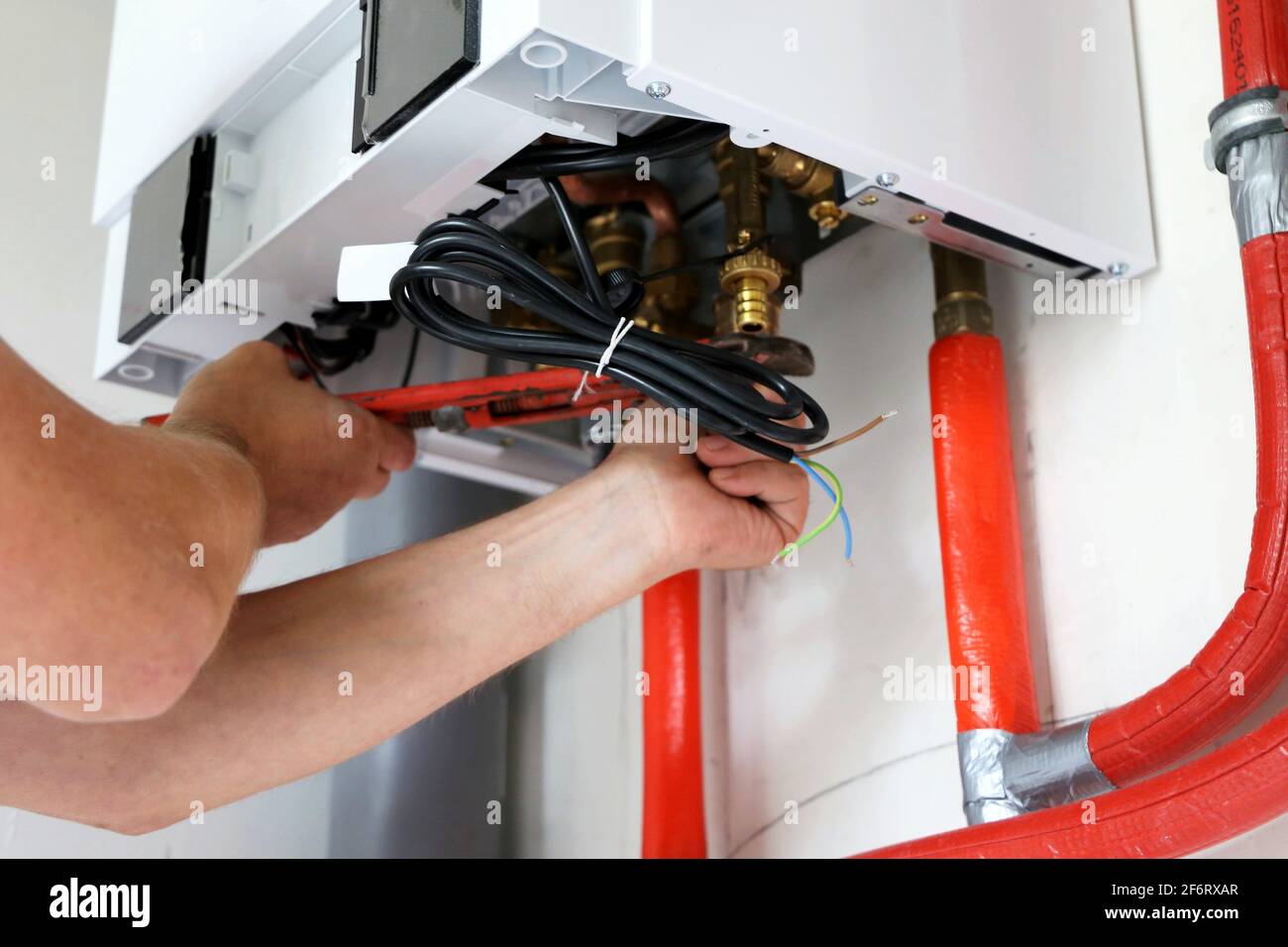New gas boiler or work on the gas boiler in the utility room of a new building. Stock Photo