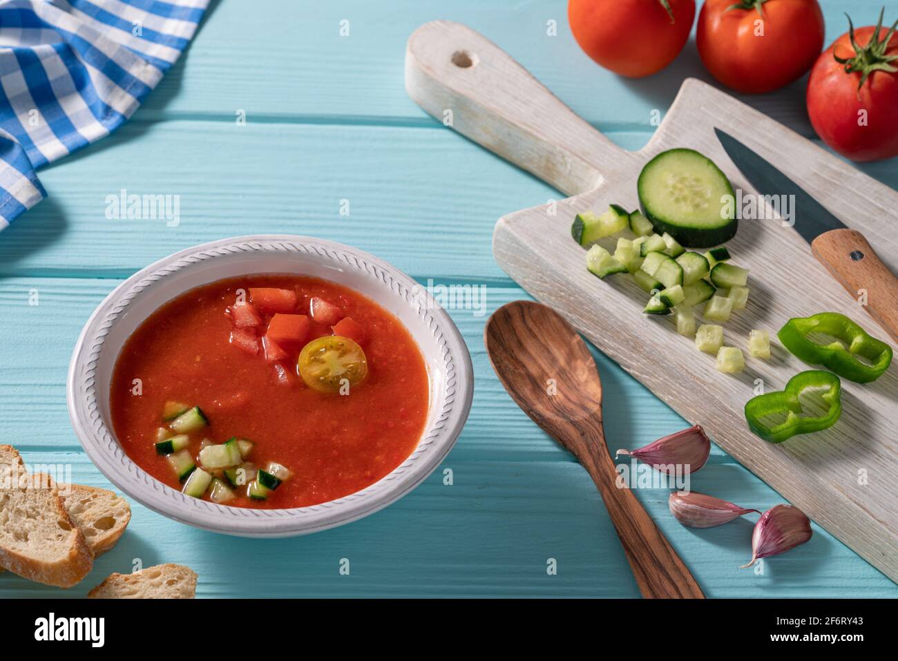 Gazpacho Andaluz is an Andalusian tomato cold soup from Spain with cucumber, garlic, pepper on light blue background. Stock Photo