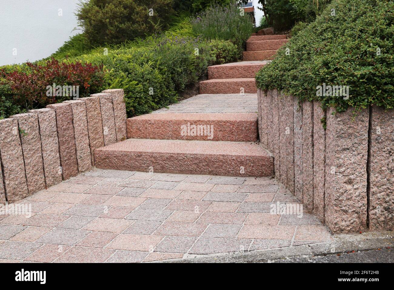 Neat and tidy front yard with solid block steps, decorative gravel and planting. Stock Photo