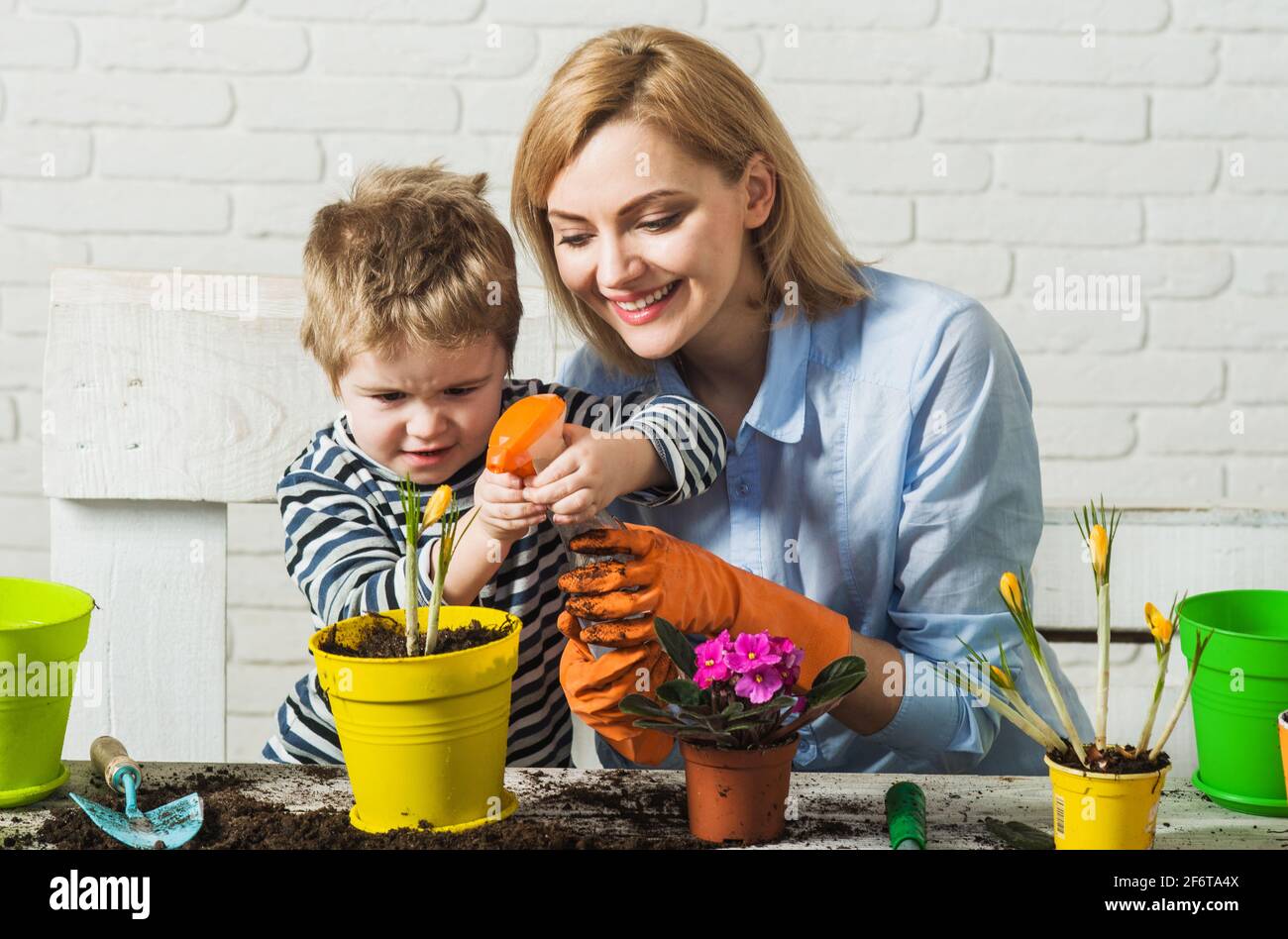 Planting together. Mother and son planting flowers. Family