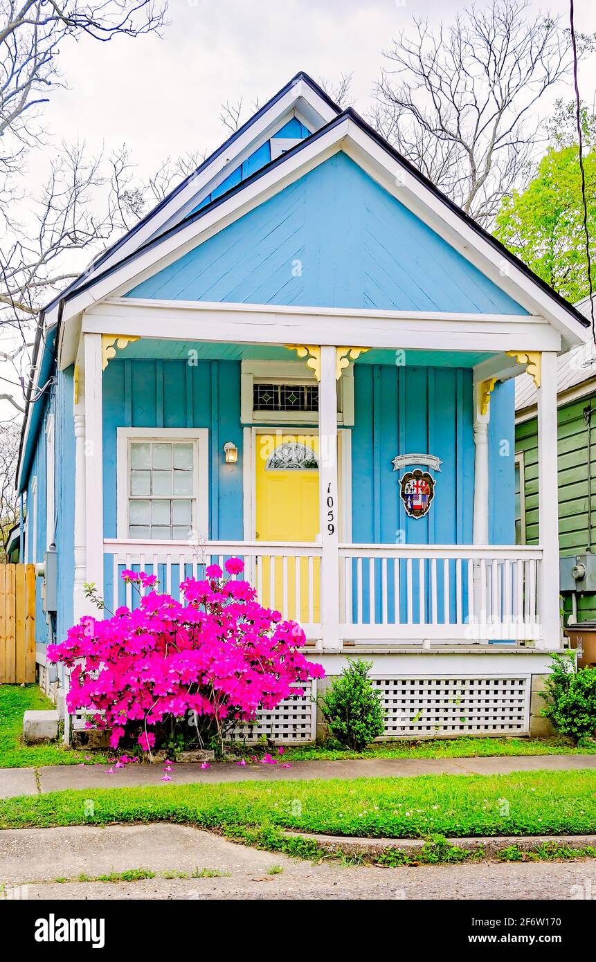 A century-old shotgun house is repurposed as an Airbnb vacation rental on Caroline Avenue in the Old Dauphin Way Historic District in Mobile, Alabama. Stock Photo