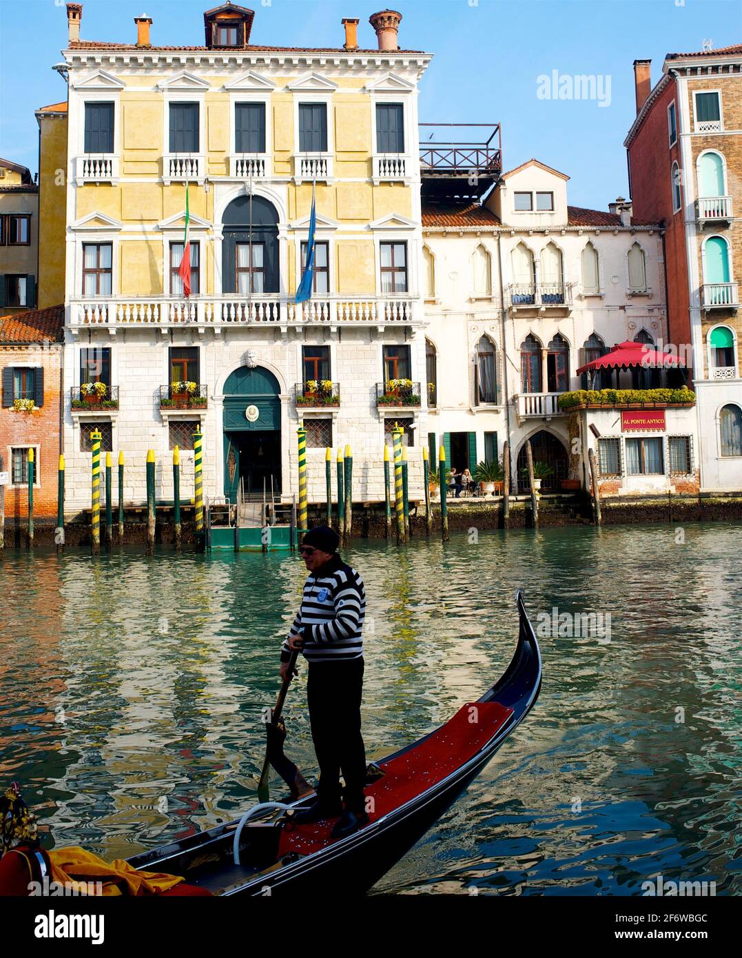 Man Rowing Boat In Canal By Building Stock Photo