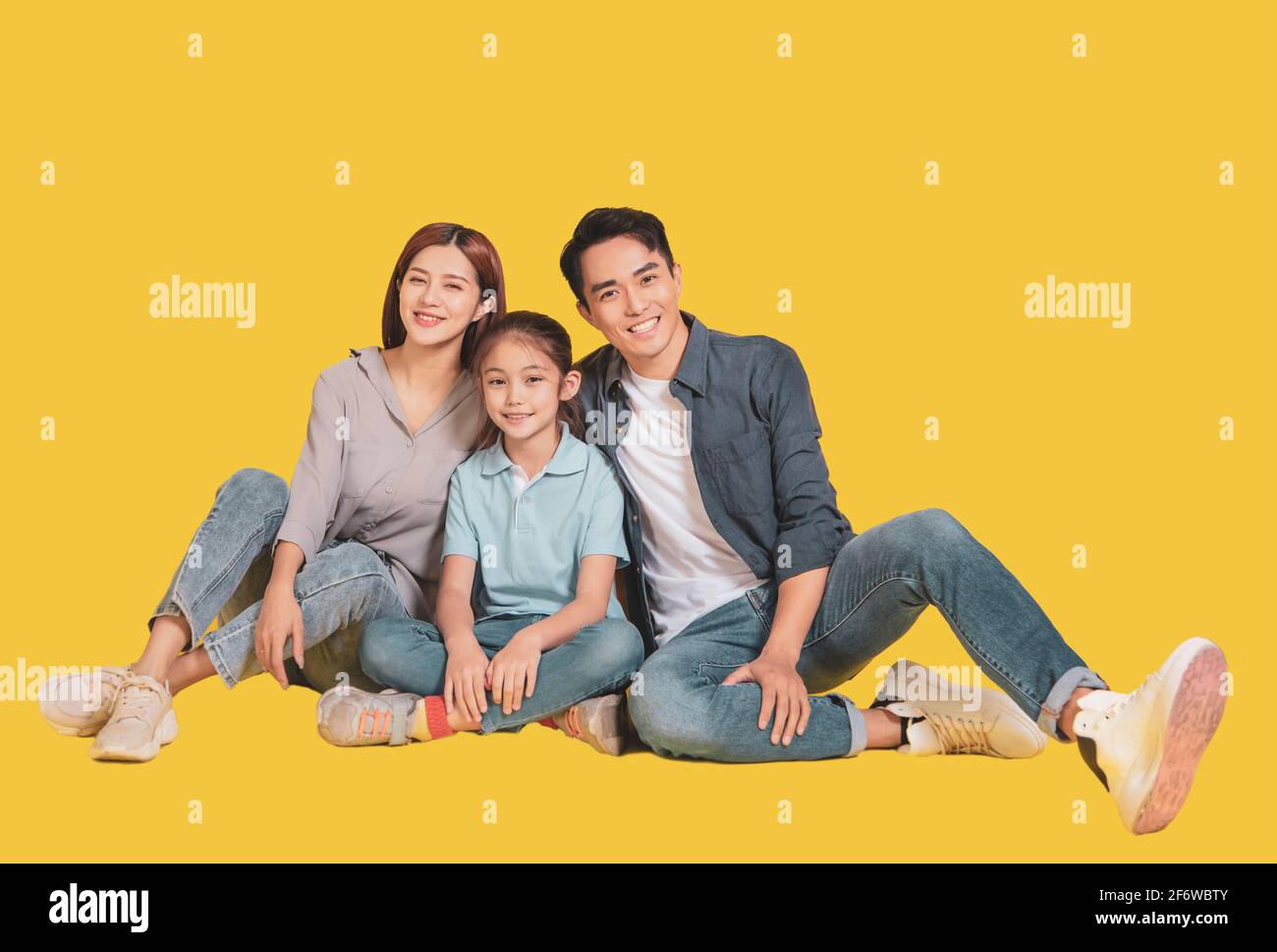 Happy Asian young family with one child sitting  and smiling at camera Stock Photo