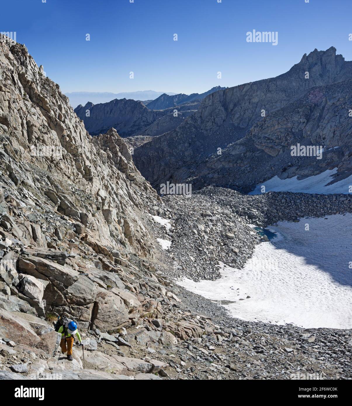 woman scrambling up steep rock and talus towards Echo Col in the Sierra Nevada Mountains Stock Photo