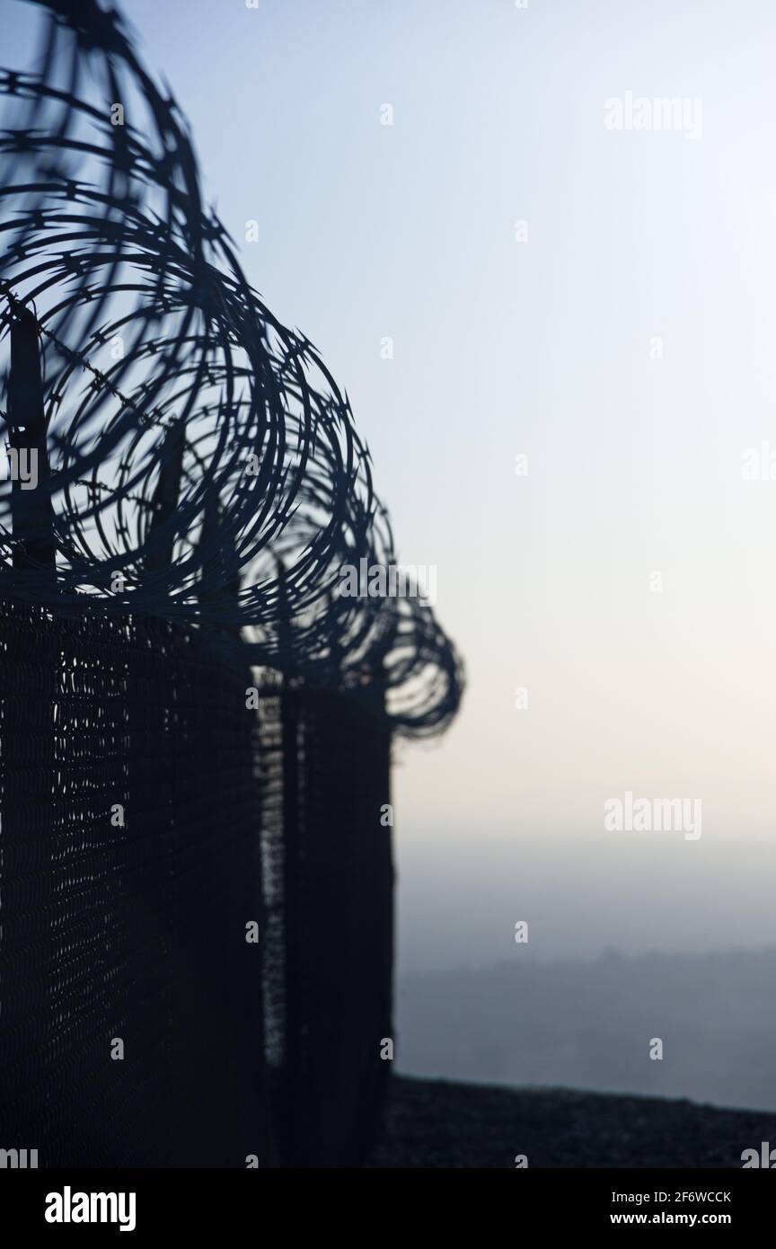 vertical image of razor wire fence with selective focus Stock Photo