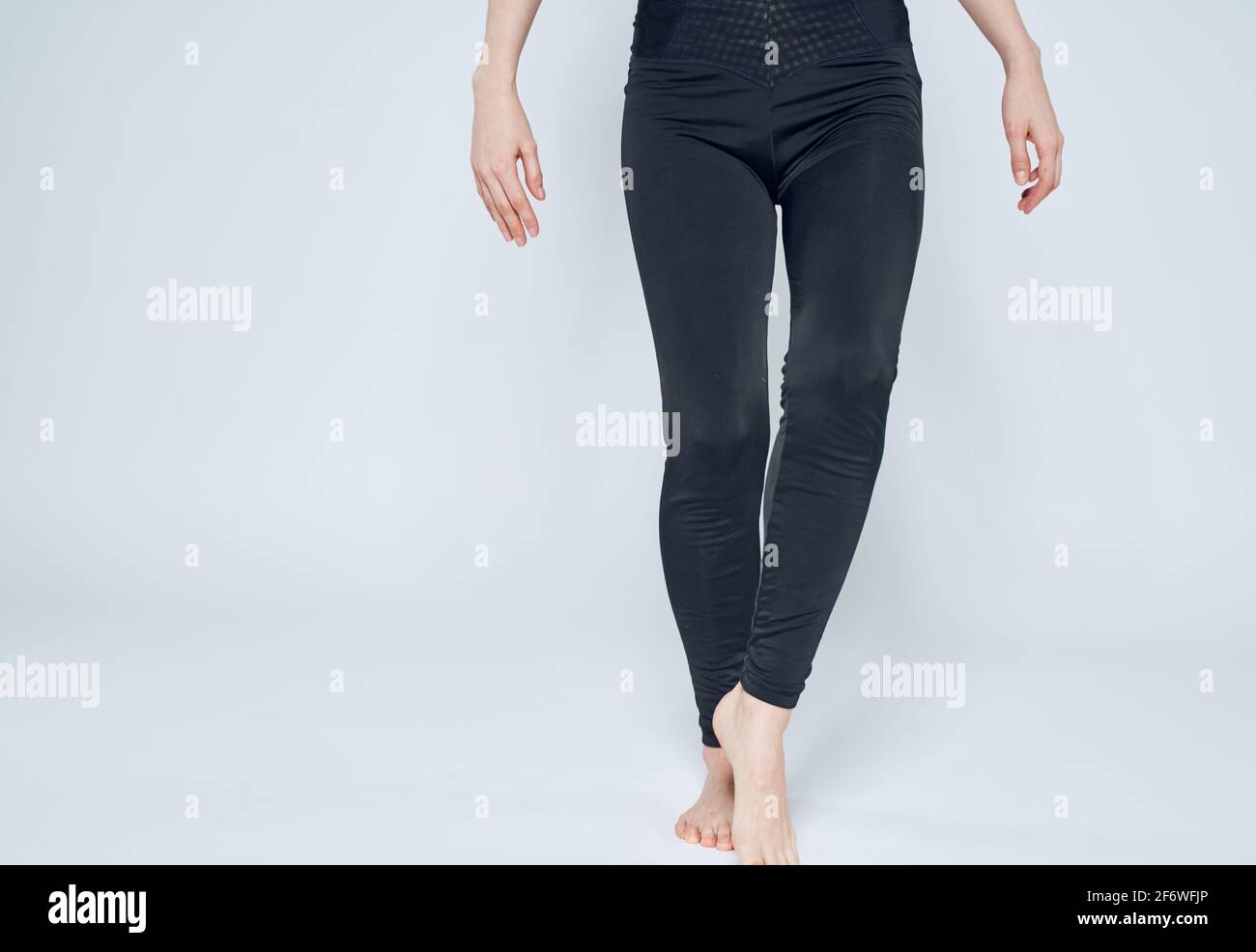Sporty woman on a light background in black leggings barefoot Stock ...