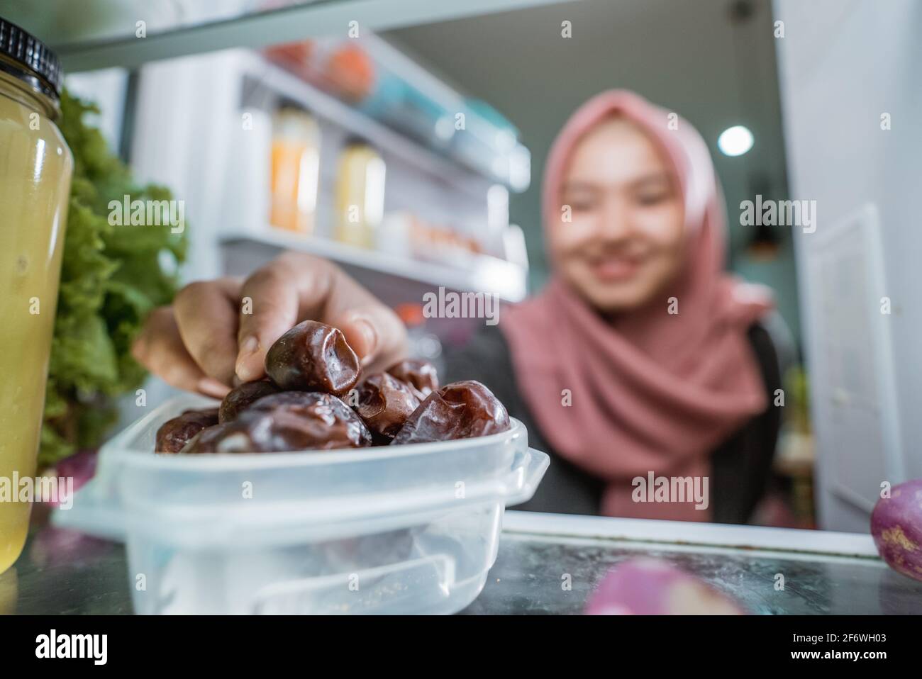 muslim asian woman eating dates fruit from the fridge Stock Photo Alamy
