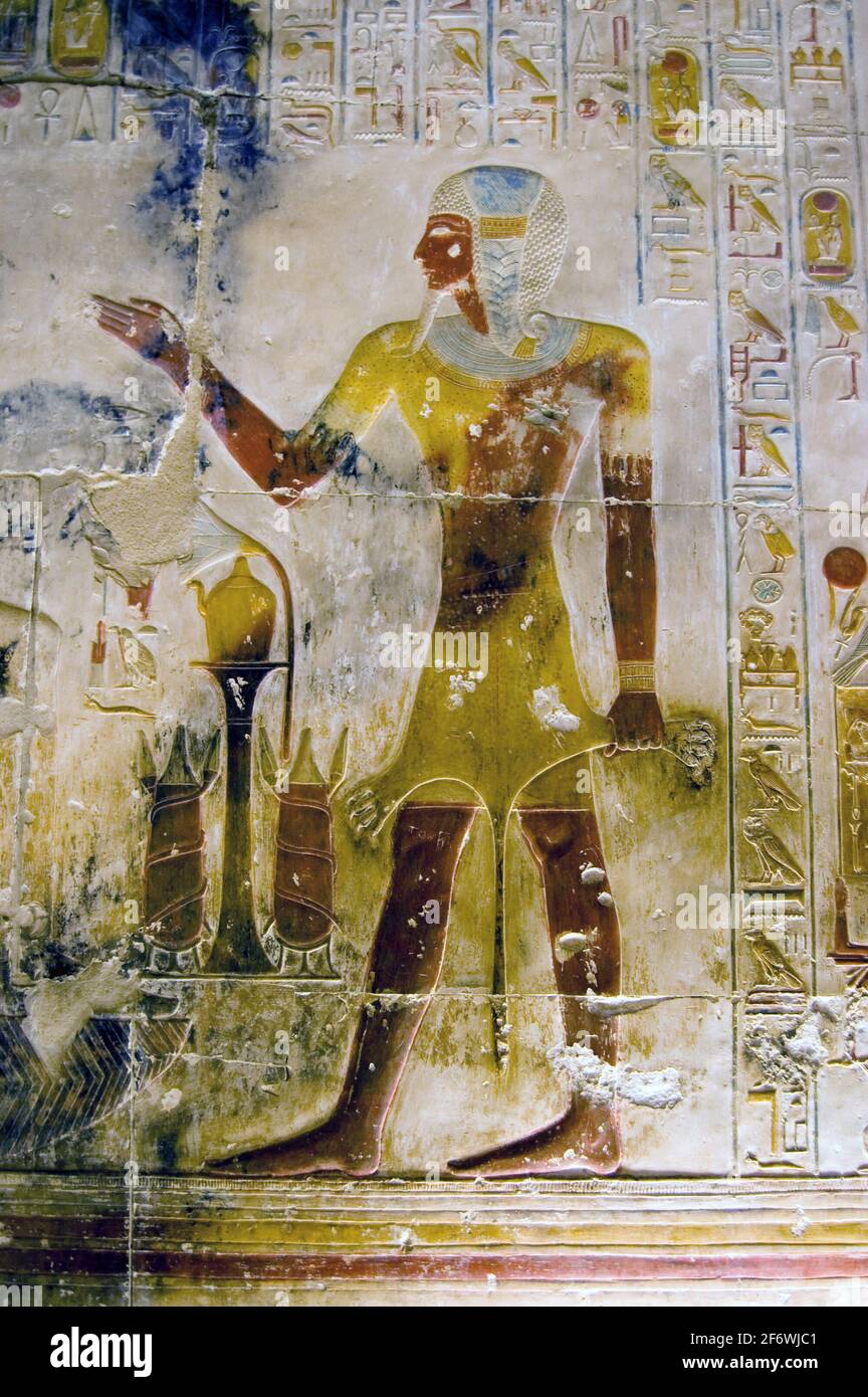 An ancient Egyptian painted hieroglyphic carving of the Pharoah Seti wearing the skin of a lion. Inner wall at the Temple to Osiris at Abydos, Egypt. Stock Photo