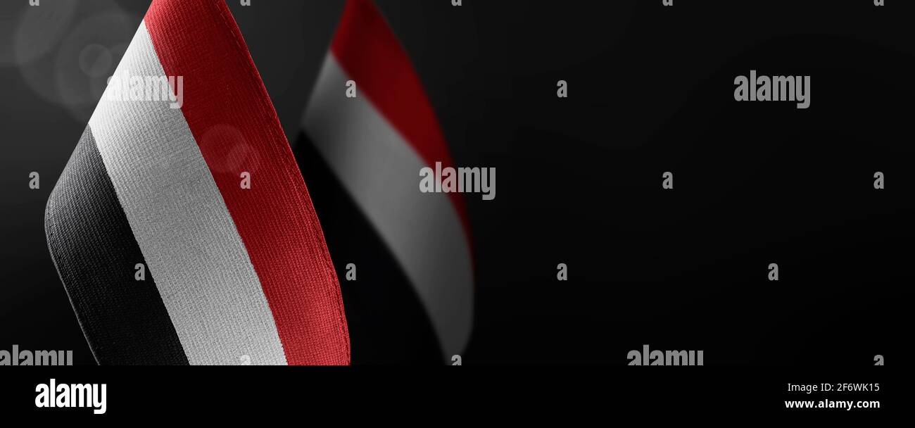 Small national flags of the Yemen on a dark background Stock Photo