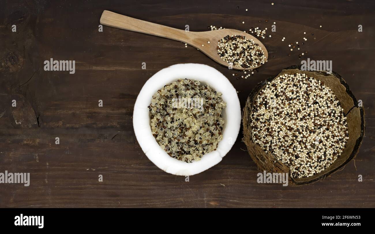 View from above of the superfood tricolor quinoa both cooked and raw inside a coconut on a wooden base Stock Photo