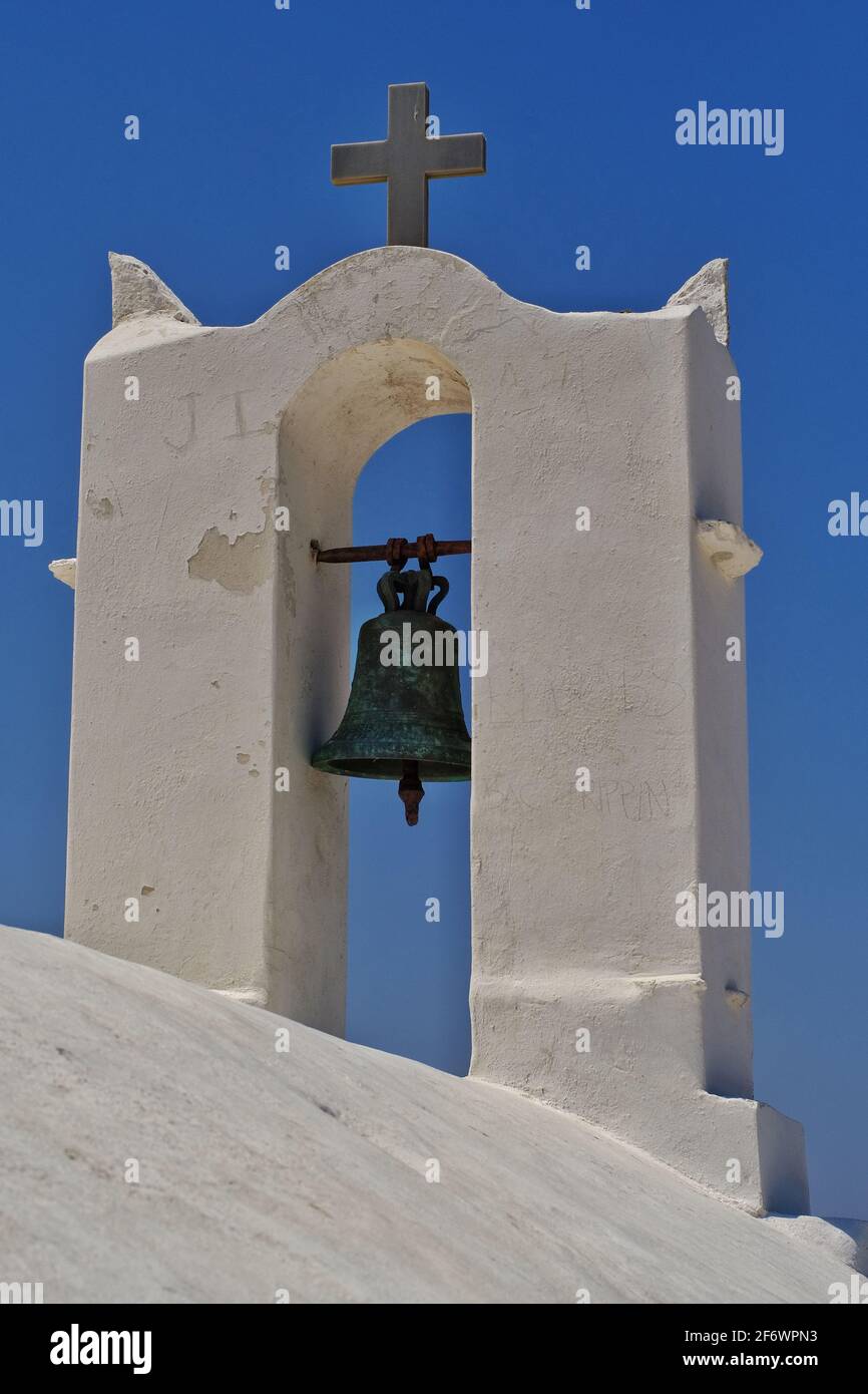 A religious cross and a bell at the top of an orthodox chapel in Ios Greece Stock Photo