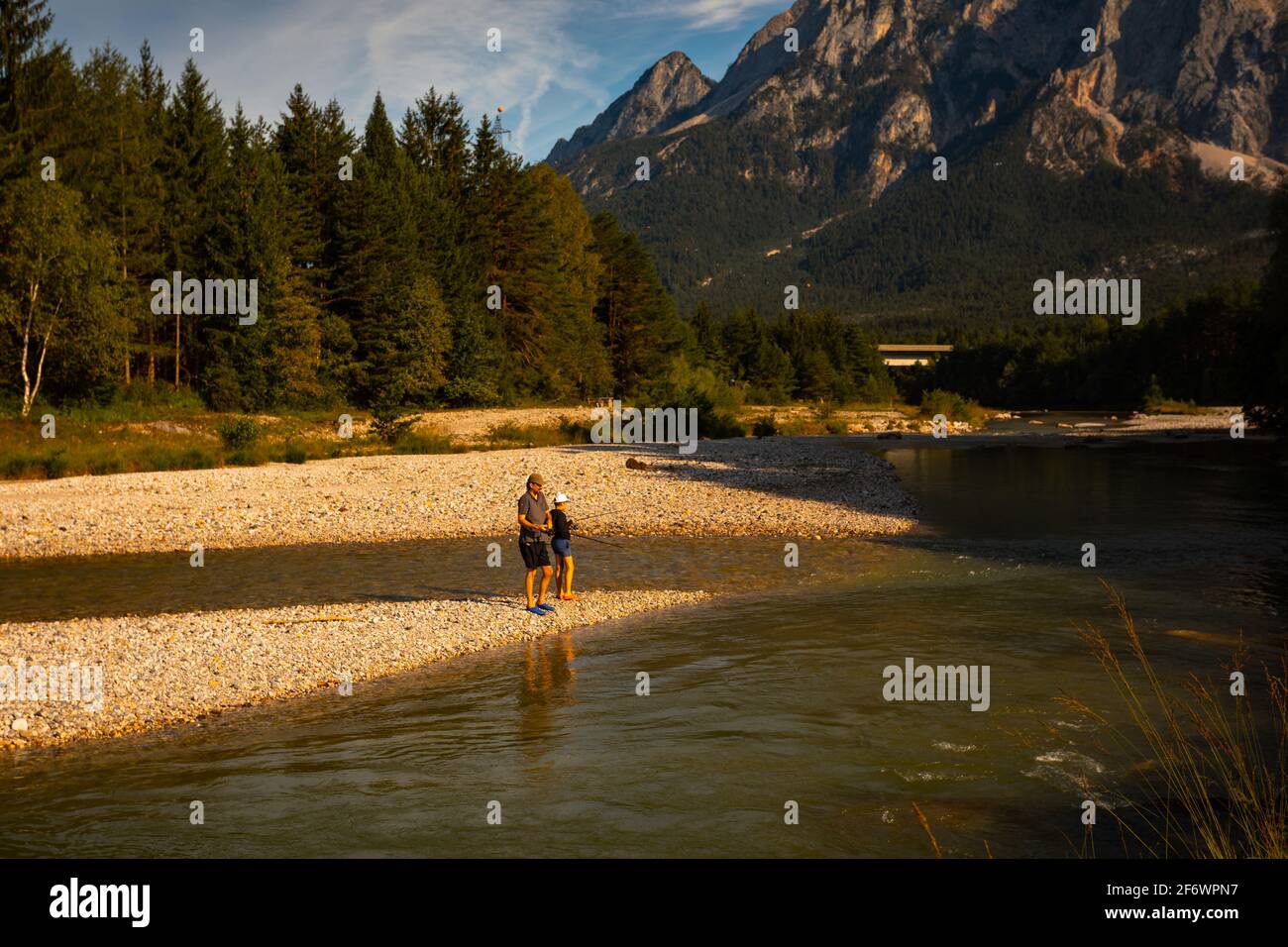 Father and son fishing on Gaililz river at sunset, Austria Stock Photo