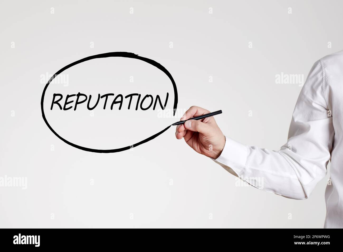 Businessman writes the word reputation with an outline circle on gray background. Business or company reputation concept. Stock Photo