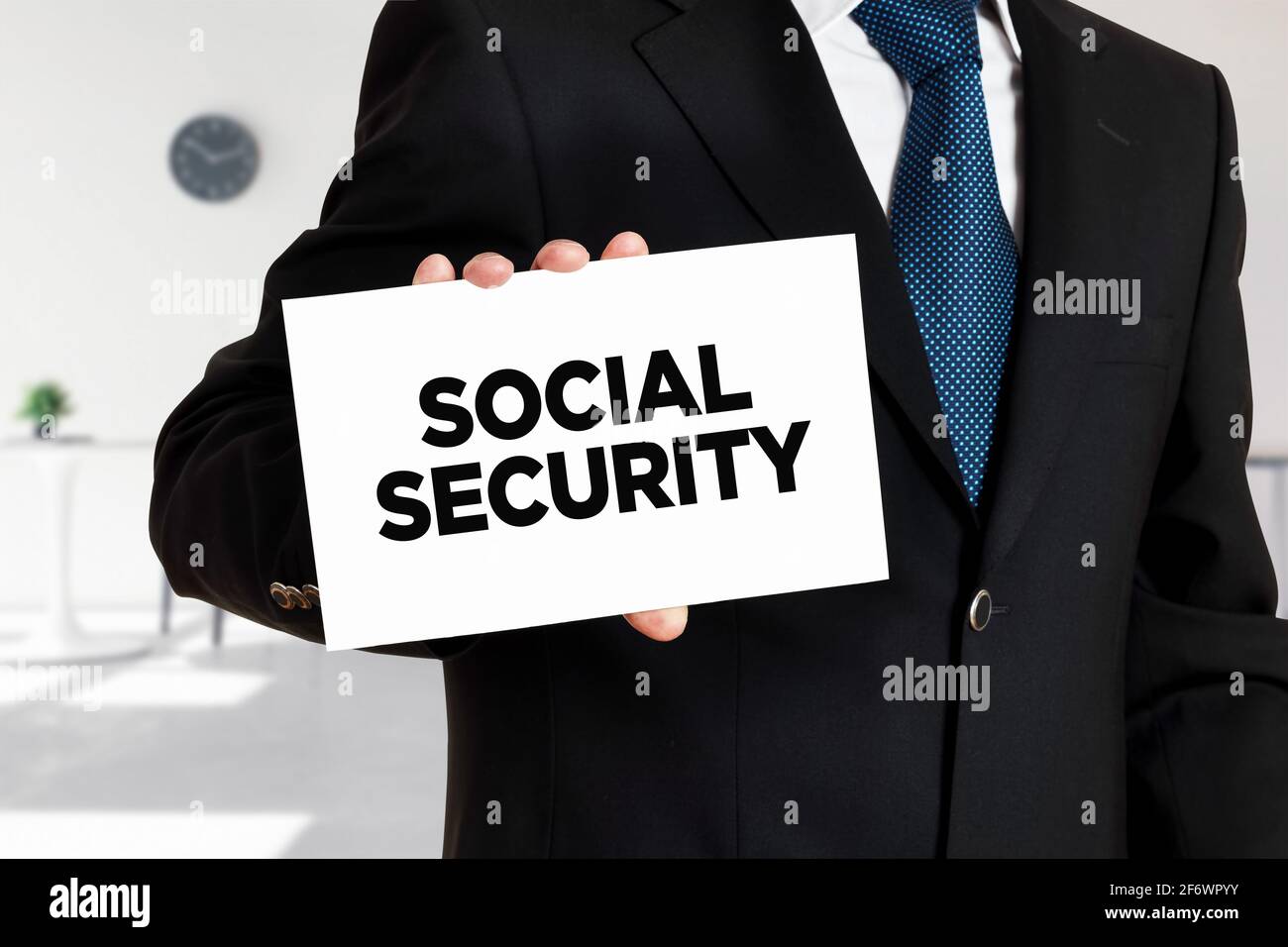 Businessman holds a card with the word social security written. Stock Photo