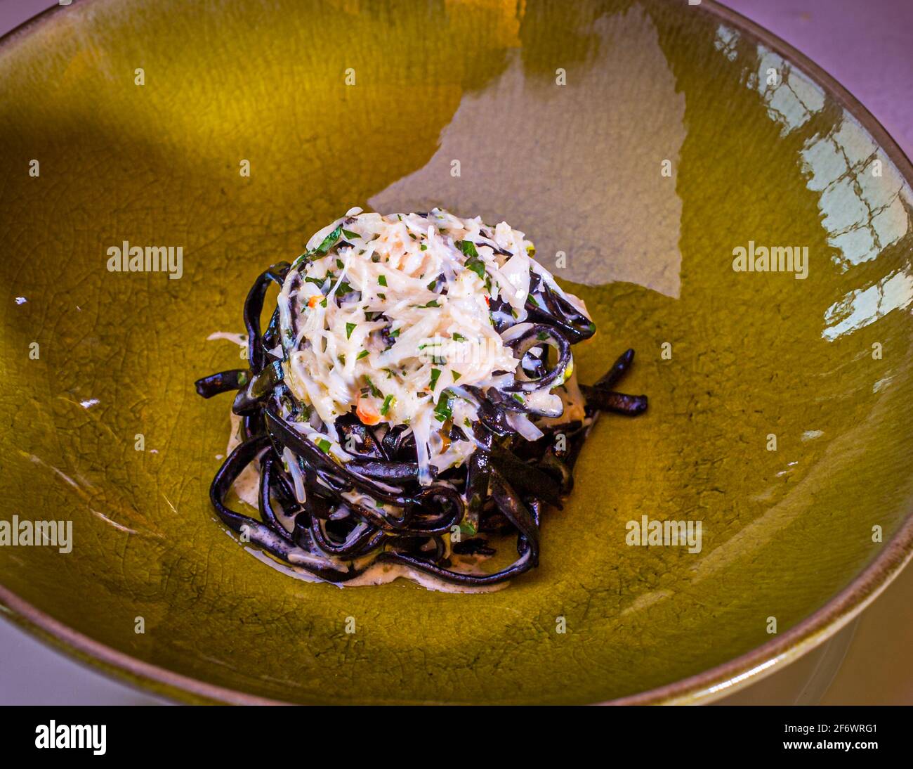 Maccaroni a la guitarra - Sepia noodles with crab meat and wild sorrel Stock Photo