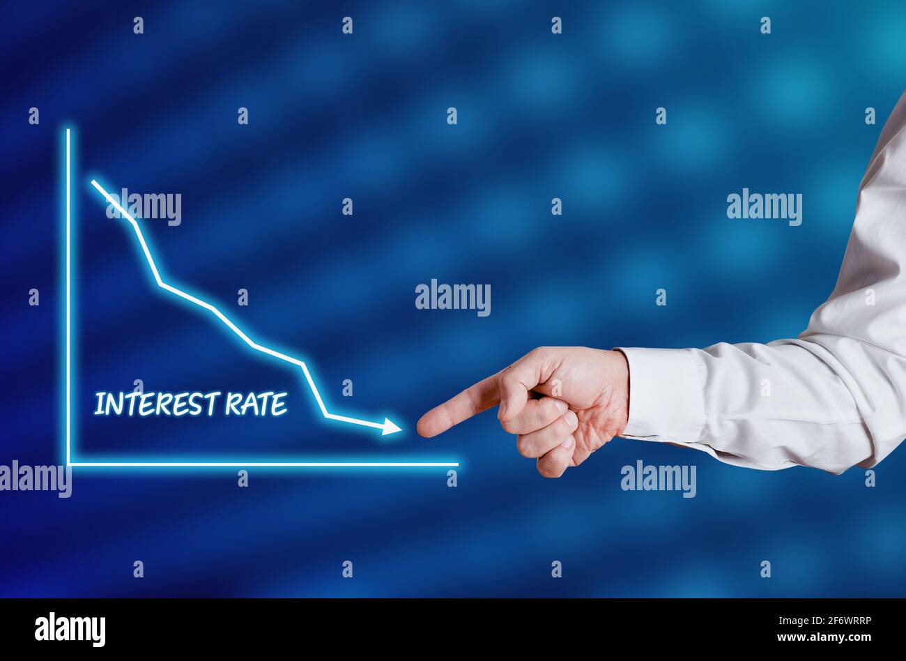 Businessman hand points to the word interest rate with a decreasing chart or graph. Declining trend in interest rates, economy business concept. . Stock Photo