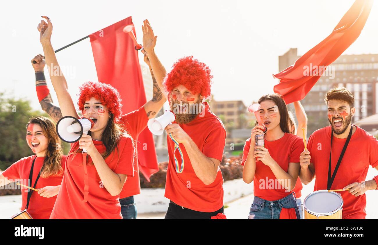 Football fans watching soccer match event at stadium - Young people having fun supporting favorite club - Sport entertainment concept Stock Photo