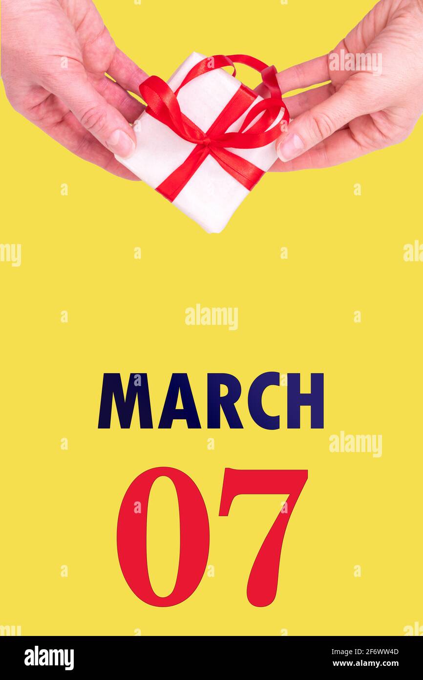 March 7th. Festive Vertical Calendar With Hands Holding White Gift Box With  Red Ribbon And Calendar Date 7 March On Illuminating Yellow Background. Sp  Stock Photo - Alamy