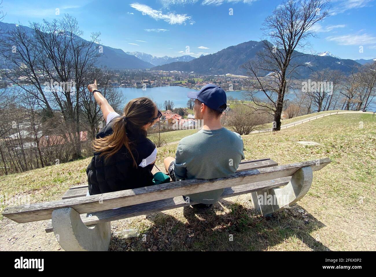Rottach Egern, Deutschland. 01st Apr, 2021. Young couple take a rest on a bench. Hikers on the Hoehenweg over the Tegernsee with a view of Rottach Egern on April 1st, 2021. Spring, Sunshine, Ausfluegler, | usage worldwide Credit: dpa/Alamy Live News Stock Photo