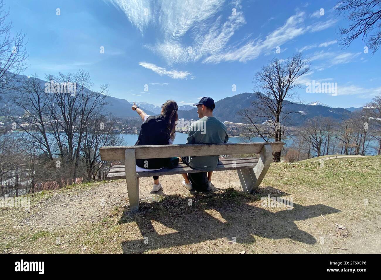 Rottach Egern, Deutschland. 01st Apr, 2021. Young couple takes a rest on a bench. Hikers on the Hoehenweg over the Tegernsee with a view of Rottach Egern on April 1st, 2021. Spring, Sunshine, Ausfluegler, | usage worldwide Credit: dpa/Alamy Live News Stock Photo