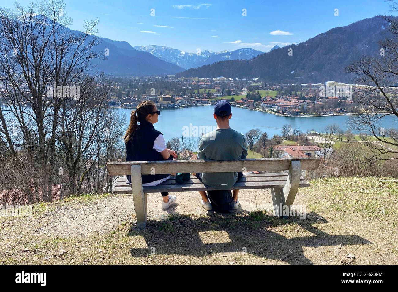 Rottach Egern, Deutschland. 01st Apr, 2021. Young couple takes a rest on a bench. Hikers on the Hoehenweg over the Tegernsee with a view of Rottach Egern on April 1st, 2021. Spring, Sunshine, Ausfluegler, | usage worldwide Credit: dpa/Alamy Live News Stock Photo