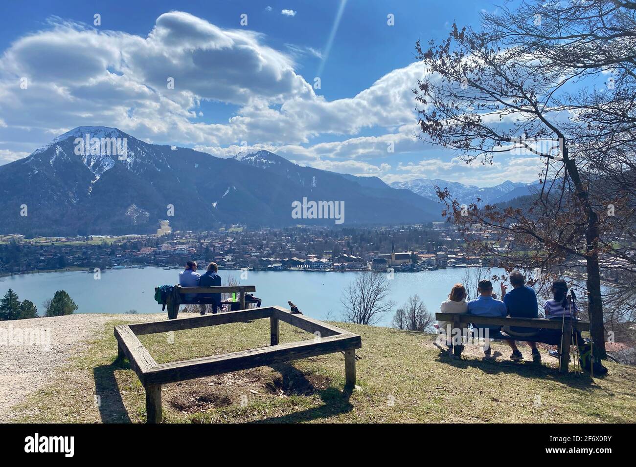 Rottach Egern, Deutschland. 01st Apr, 2021. Hikers take a rest on the banks. Hikers on the Hoehenweg over the Tegernsee with a view of Rottach Egern on April 1st, 2021. Spring, Sunshine, Ausfluegler, | usage worldwide Credit: dpa/Alamy Live News Stock Photo