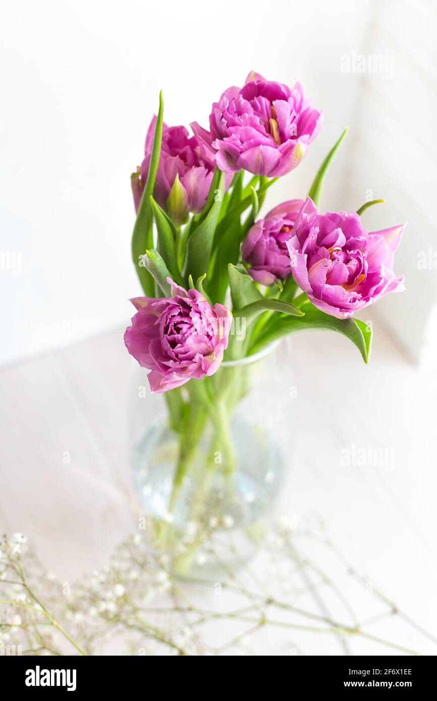 Romantic delicate bouquet of pink tulips in a glass vase on a light ...