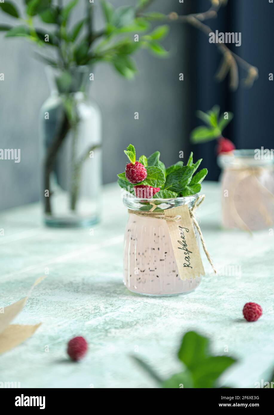 Close up of homemade detox drink made of raspberry, basil seeds and mint leaves. Decorated with hand written label. Refreshing drink in natural light. Stock Photo