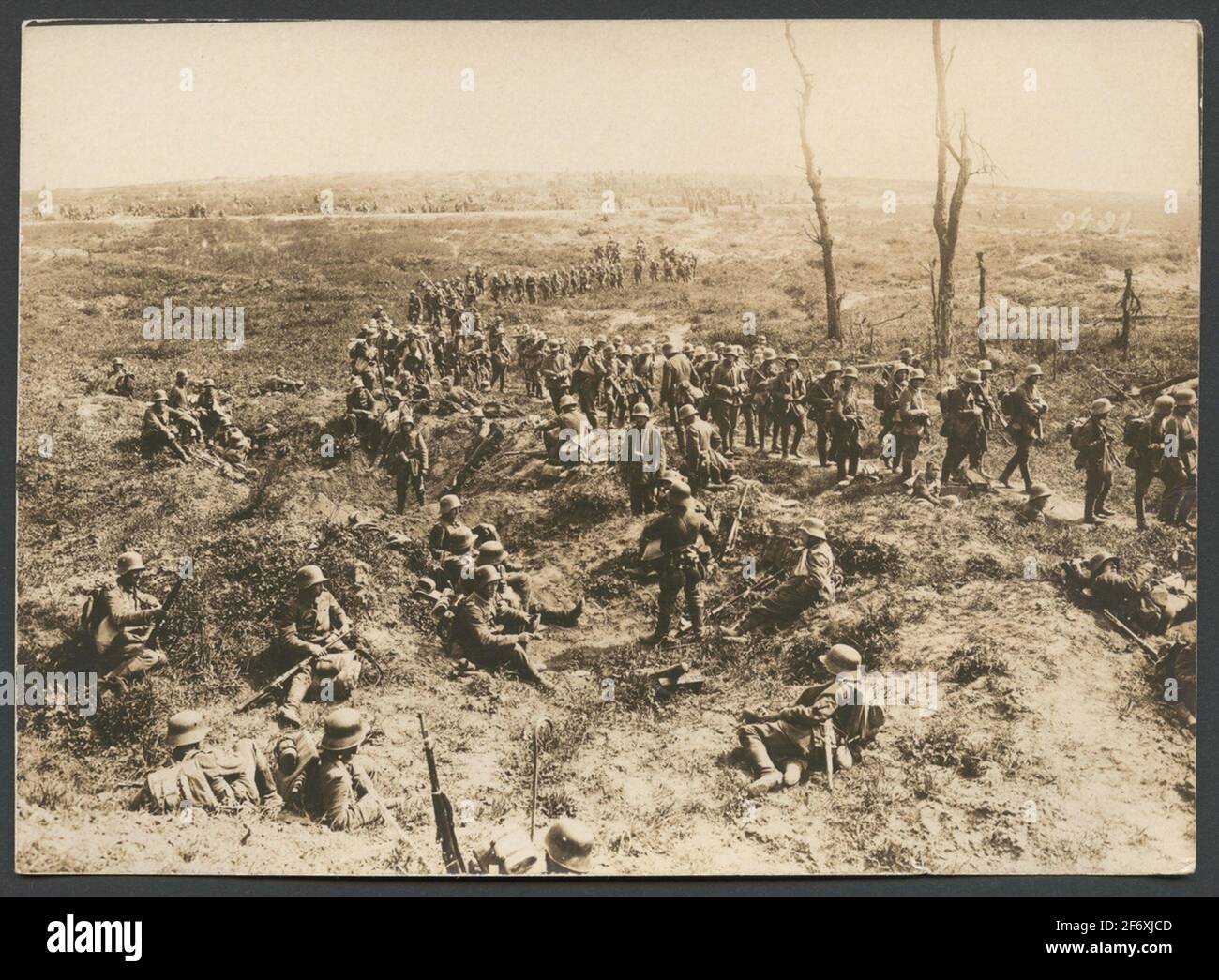 The Picture Shows A Column German Soldiers Marching Over One From Grenades Upset Battlefield In The Forehand Another Group Take A Break In The Protection Of Grenadeholes In The Background You See How A