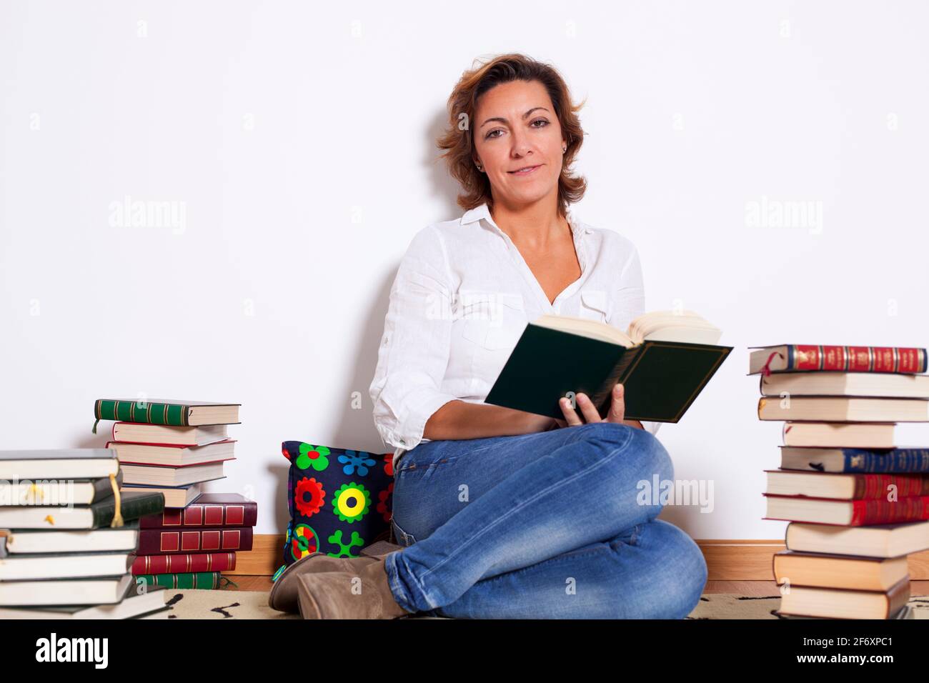 Woman at her house reading books Stock Photo