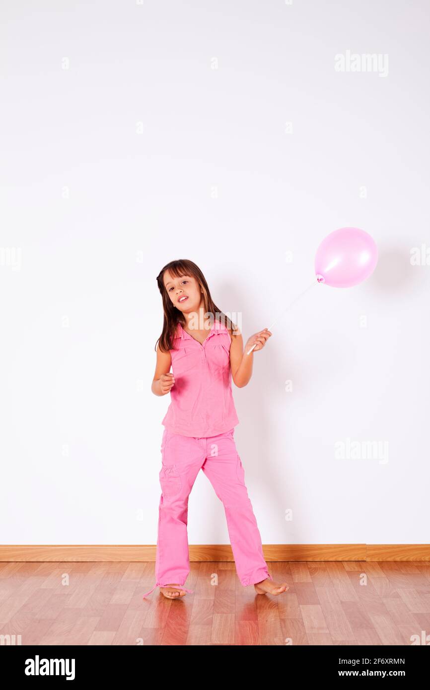 Little girl holding color balloons with gray background Stock Photo