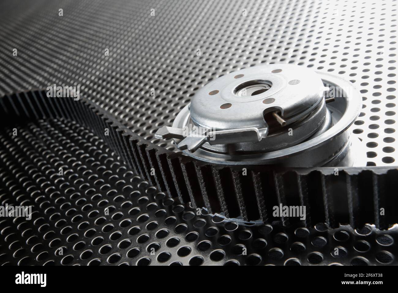 Bearing tensioner and timing belt on a metal surface. Photo from the vignetting effect Stock Photo