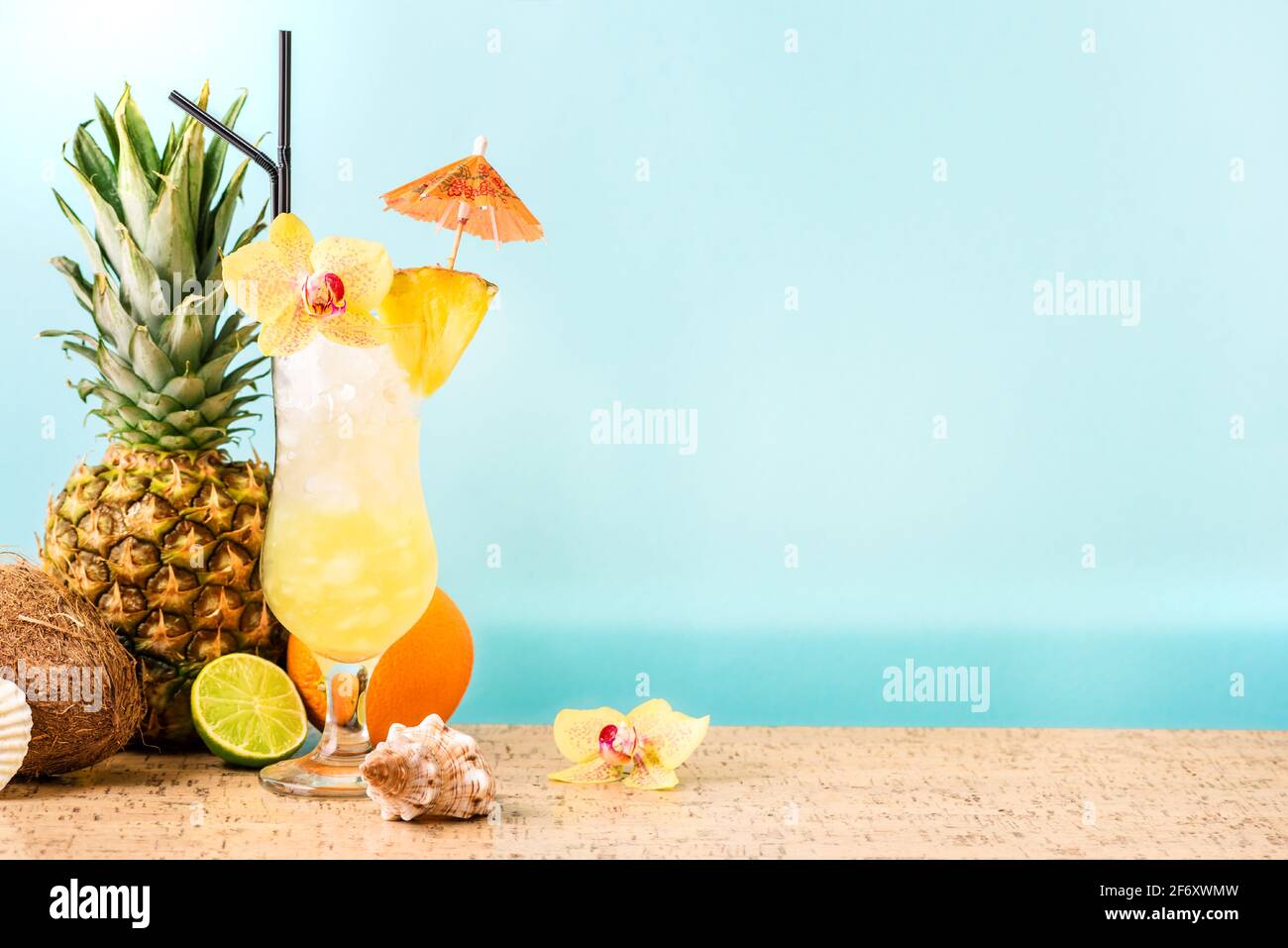 Summer tropical cocktail drink, fruits and flowers, blue sea background ...