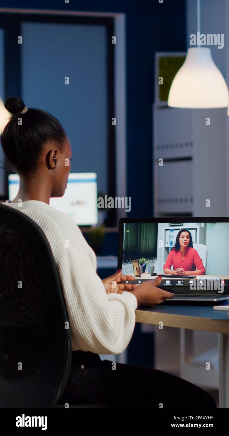 African Freelancer Working Remotely Discussing With Woman Partner Online Sitting In Front Of Laptop In Start Up Office Talking During Virtual Meeting At Midnight Using Headphone Doing Overtime Stock Photo Alamy