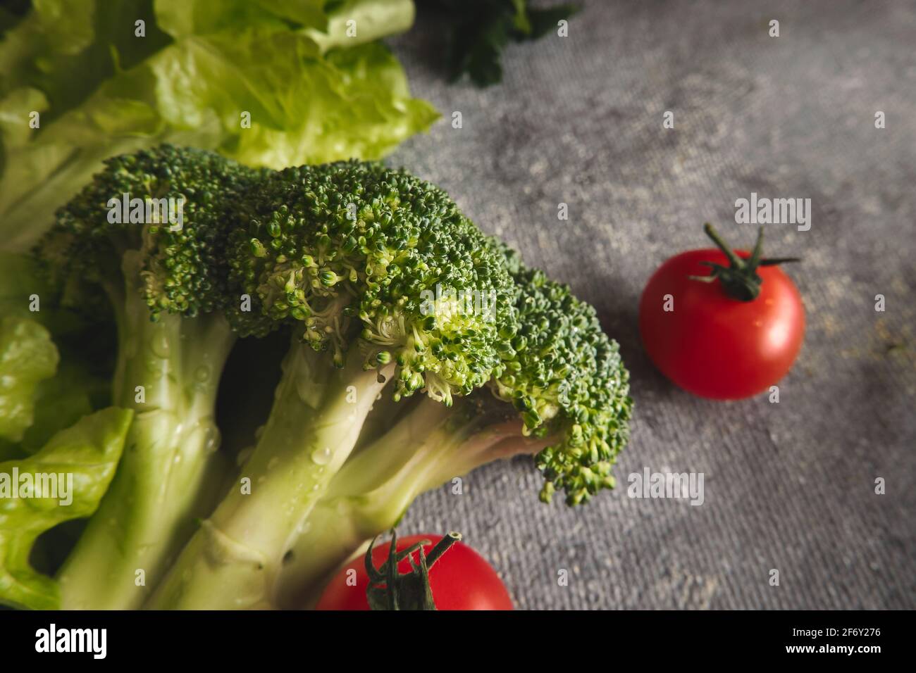 Broccoli and tomatoes on gray background Stock Photo