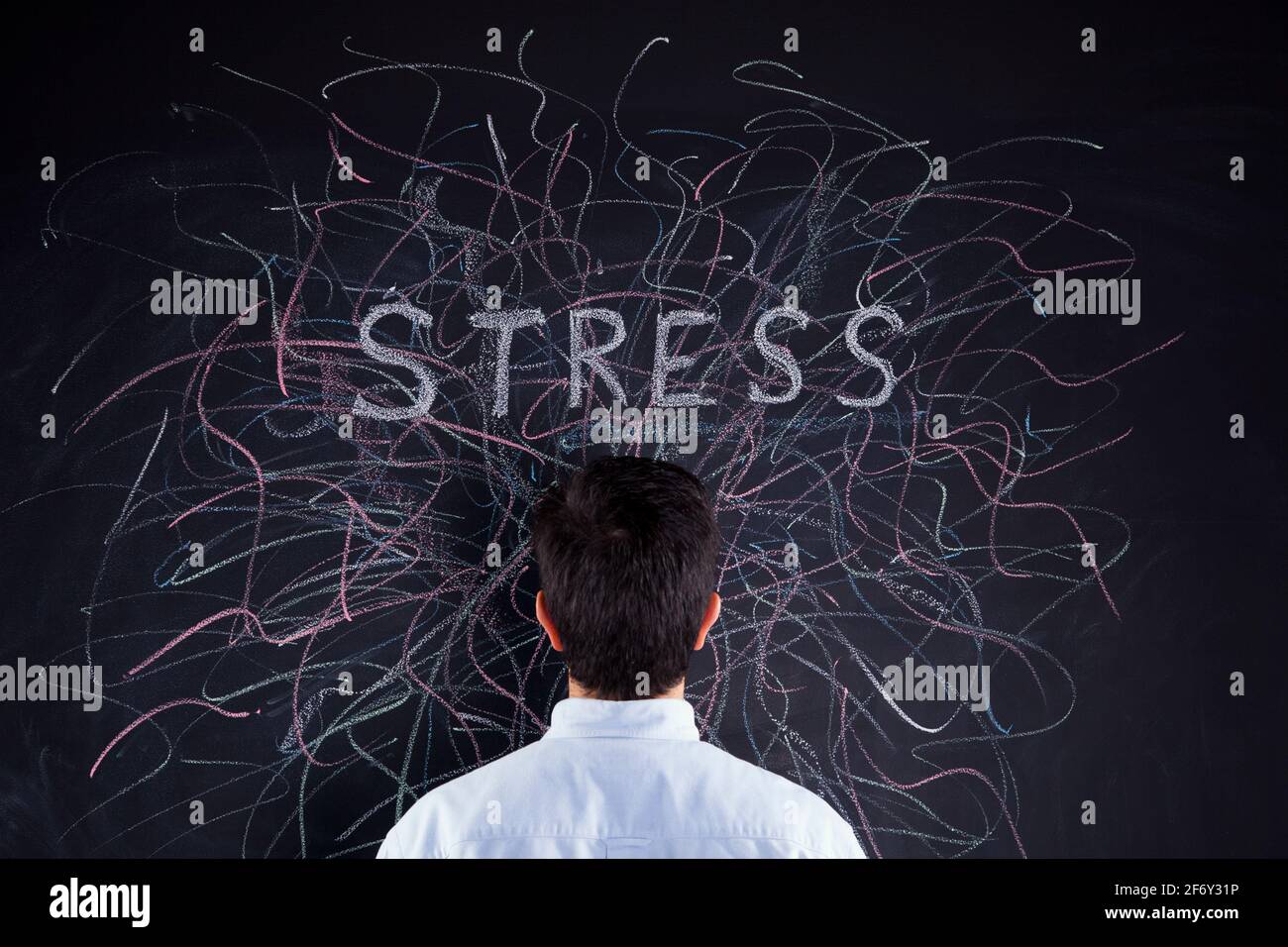 Stressed man looking to a chalkboard with lots of crazy lines Stock Photo
