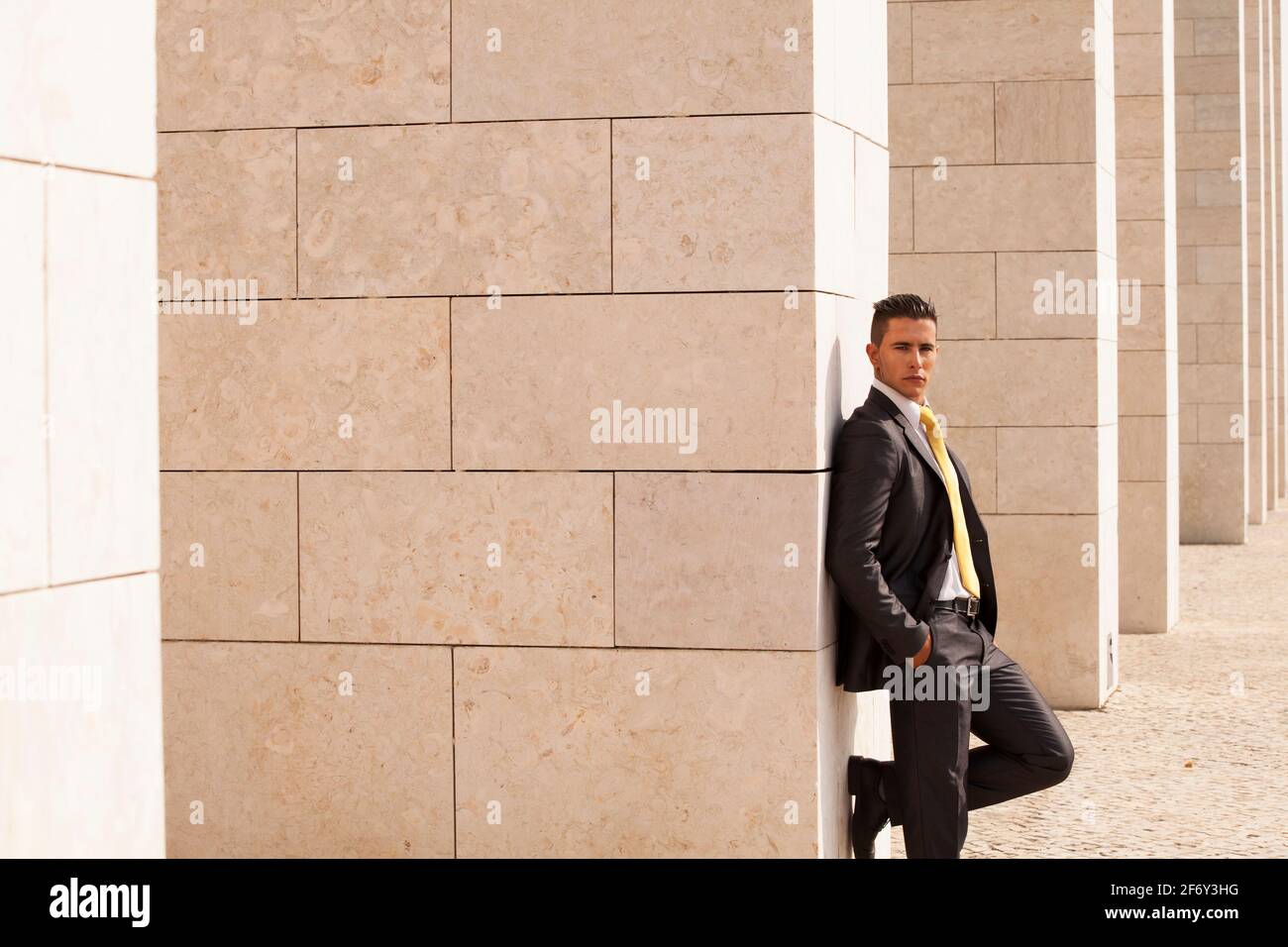 Sad businessman next to some wall looking down Stock Photo