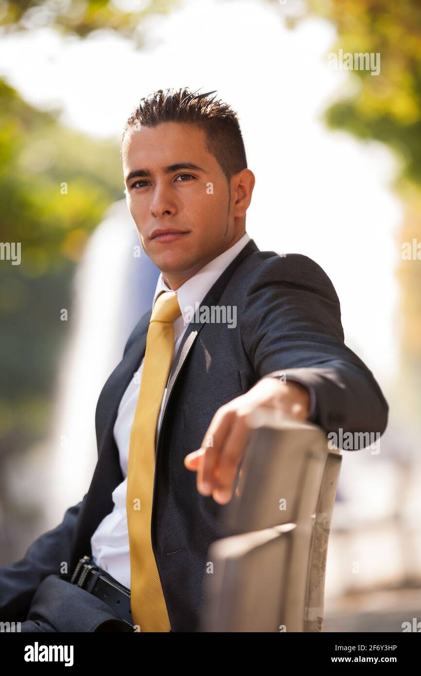 Handsome businessman sited at the bench park Stock Photo