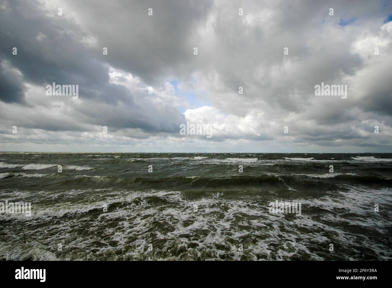 Ein heraufziehender Sturm kündigt sich mit dunklen Wolken über den Küstengewässern von Rügen an - storm coming up with dark clouds over the coastal waters of Ruegen island. Stock Photo