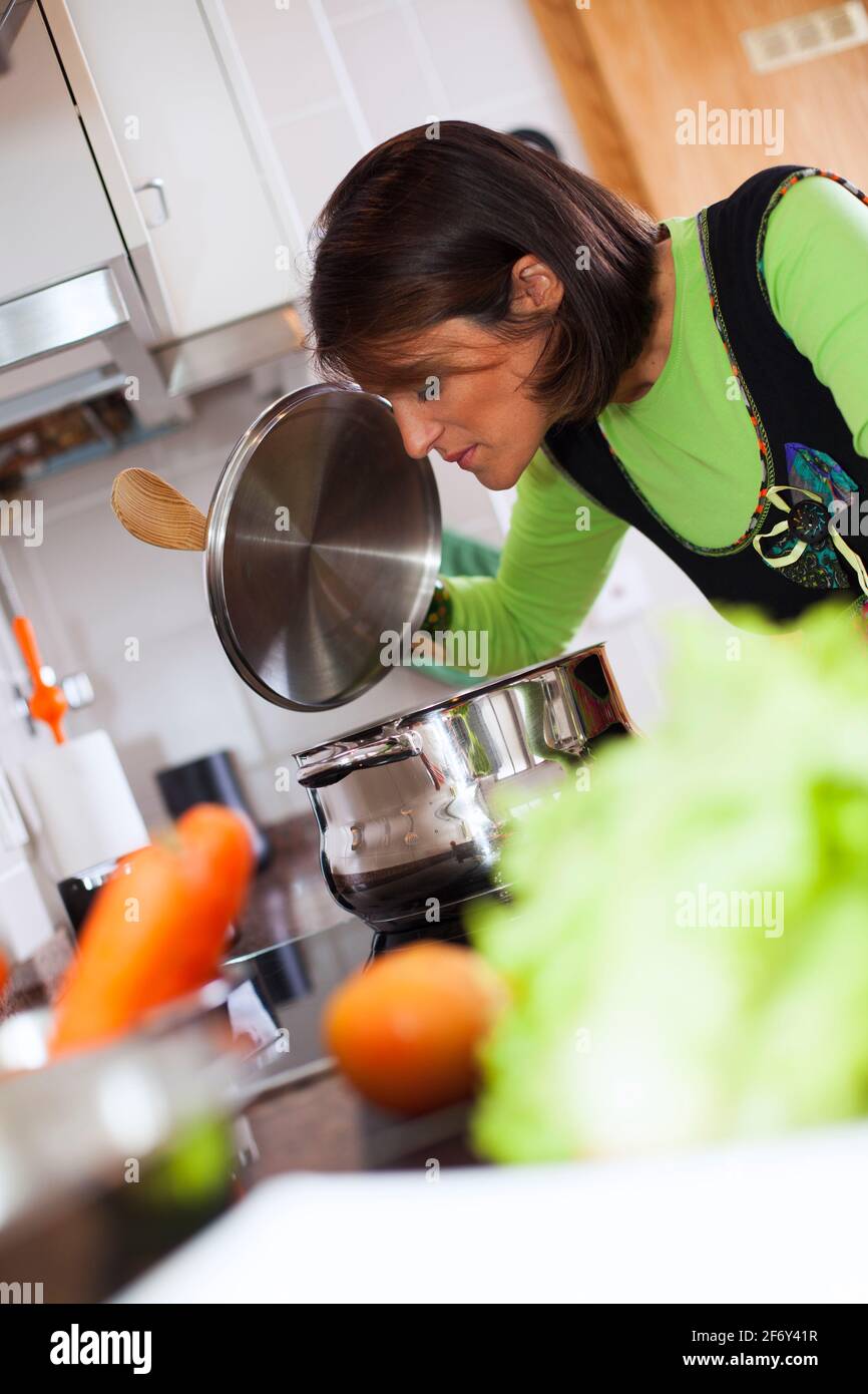 modern woman taken the food out of the kitchen oven Stock Photo