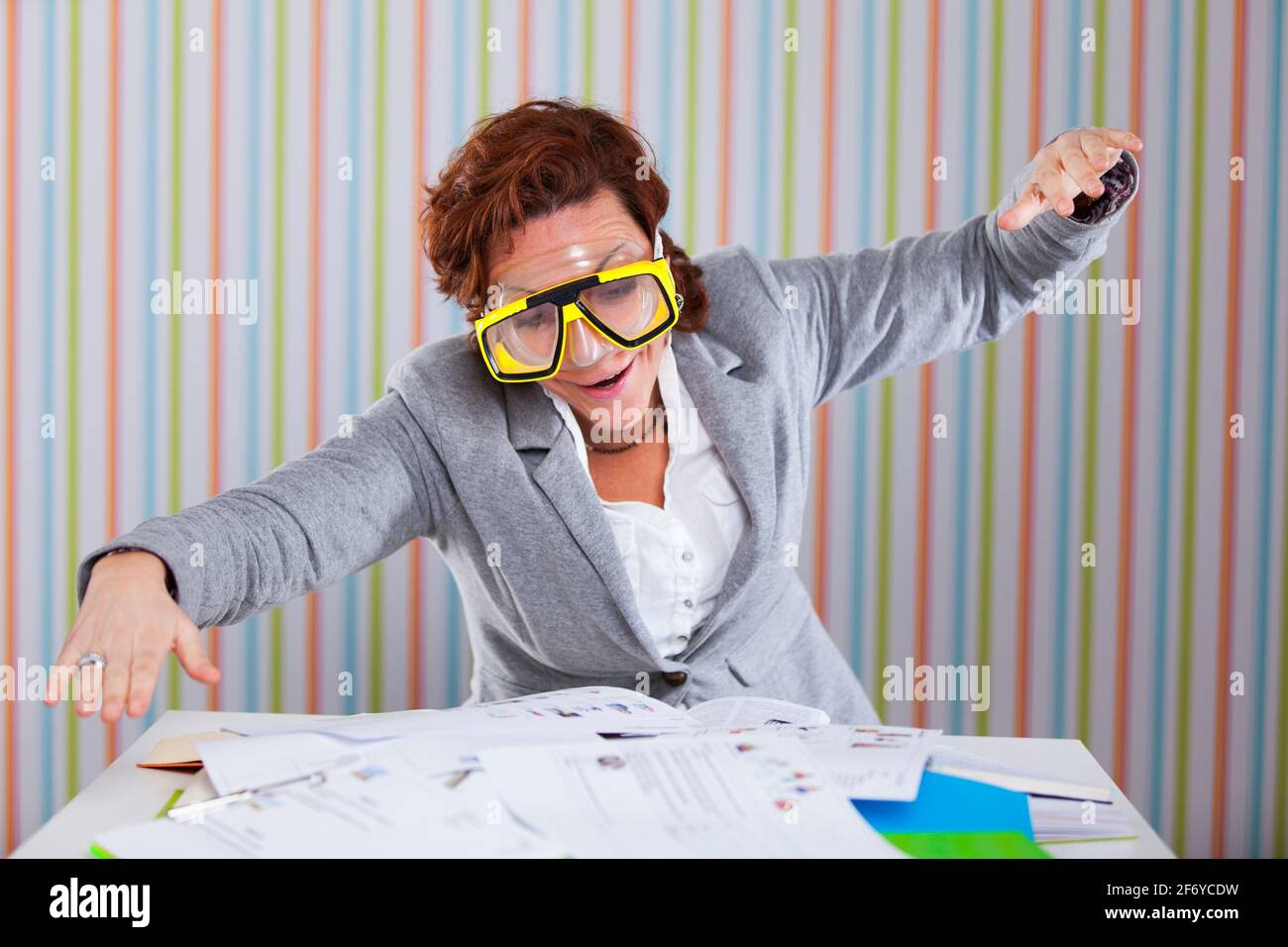 Businesswoman with a scuba mask diving in her work Stock Photo