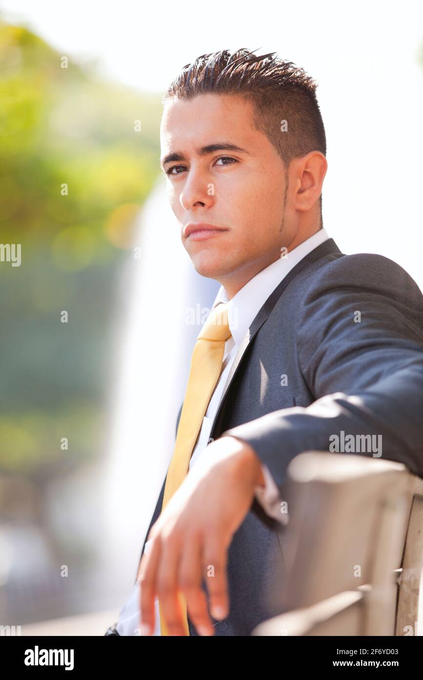 Handsome businessman sitted at the bench park Stock Photo