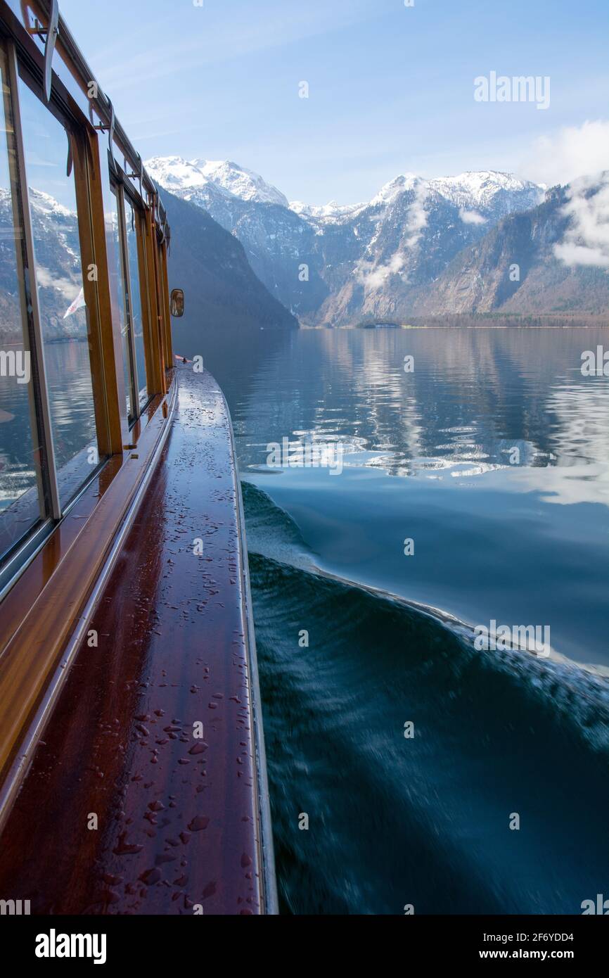 Boat on a lake Koenigssee near Berchtesgaden in Bavaria at bright daylight and reflection of the mountains on the water Stock Photo