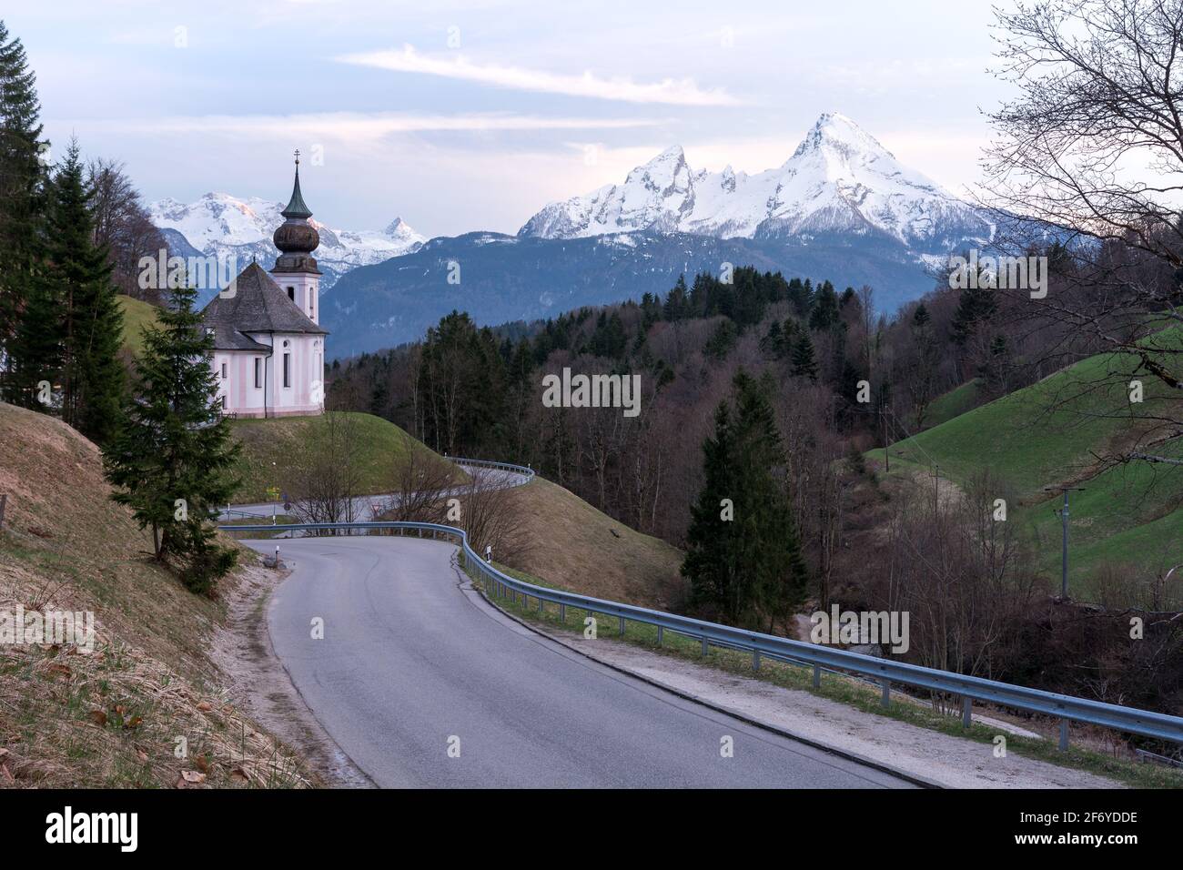 Mountain church Maria Gern near Berchtesgaden in Bavaria with road and mountain in the picture at beautiful sunset in peaceful nature Stock Photo