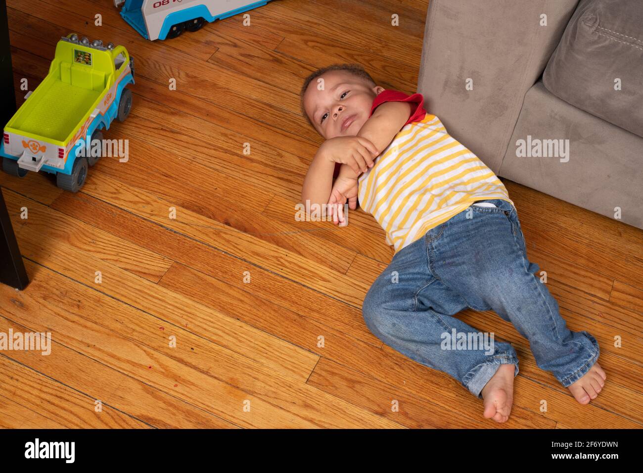 2 year old boy, tired, lying on floor, crying, tantrum Stock Photo