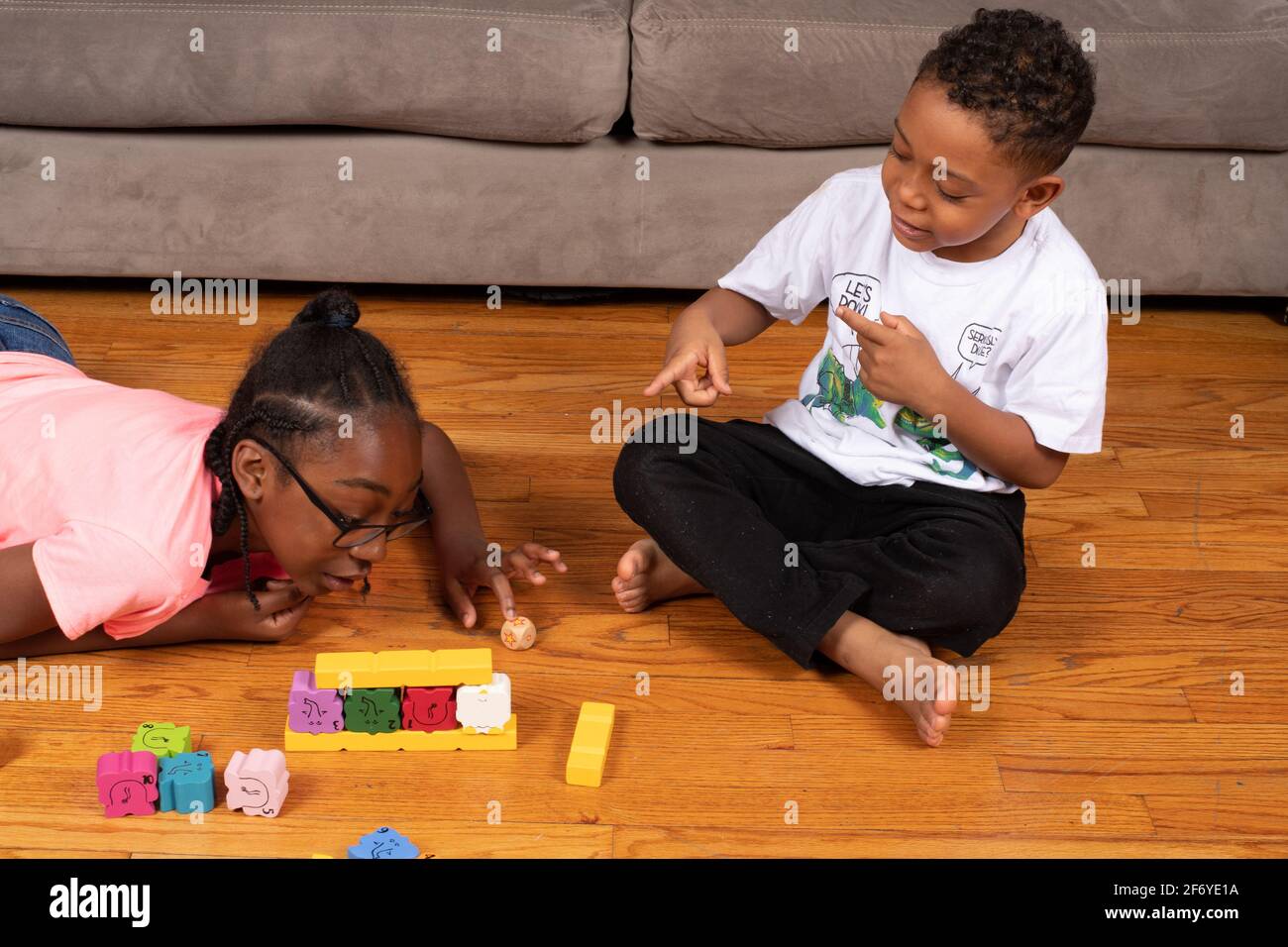 Girl, age 11, playing game with blocks with her 6 year old brother Stock Photo