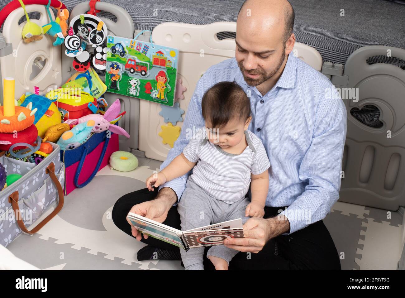 8 month old baby boy, with father, read to Stock Photo