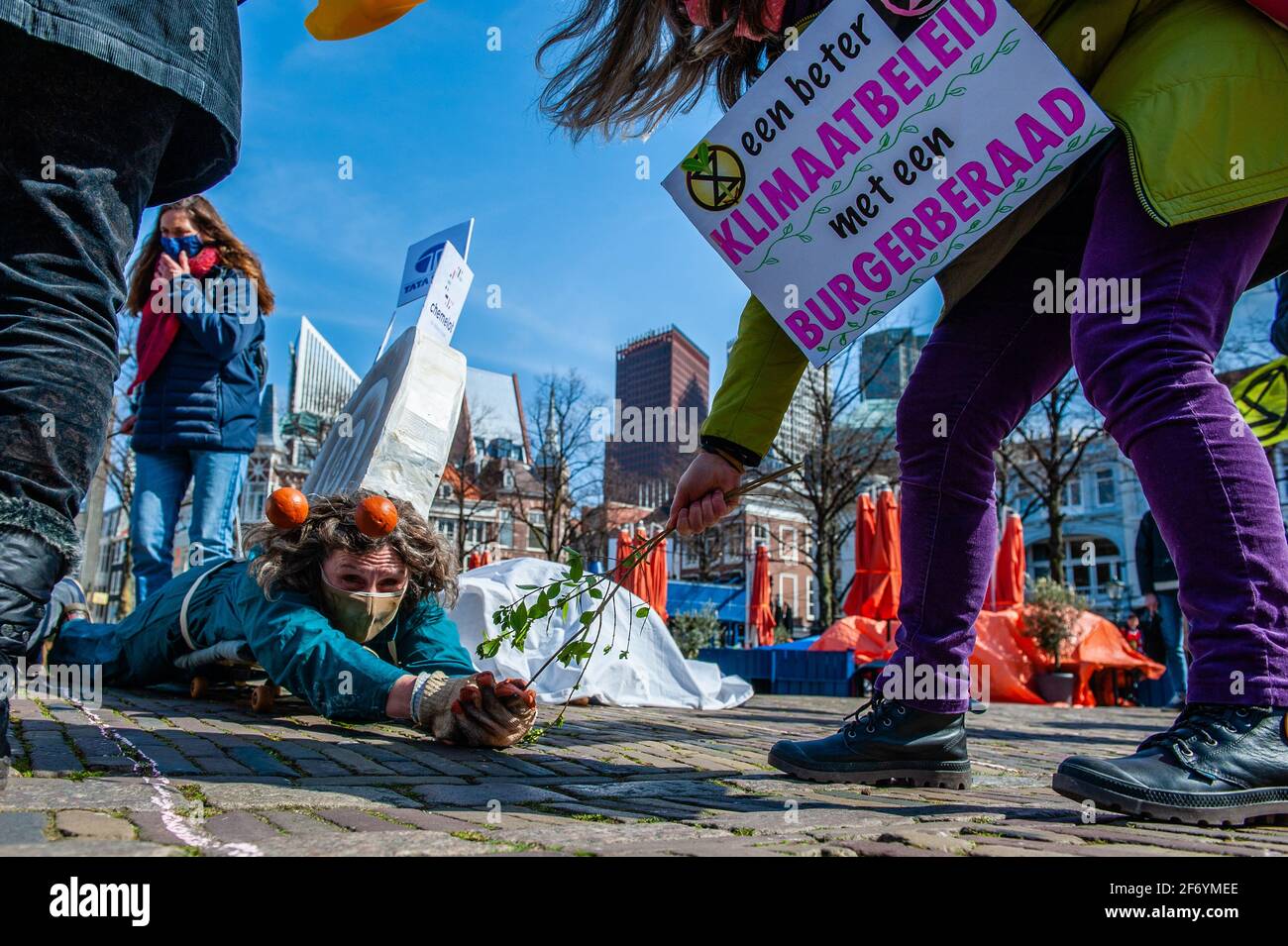 An XR activist dressed like a snail is seen trying to reach some food