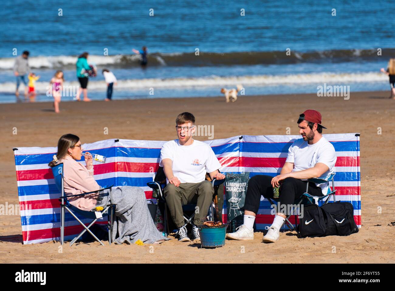 Portobello, Scotland, UK. 3 April 2021. Easter weekend crowds descend on Portobello beach and promenade to make the most of newly relaxed  Covid-19 lockdown travel restrictions and warm sunshine with uninterrupted blue skies. Pic; Picnics were popular on the beach.  Iain Masterton/Alamy Live News Stock Photo