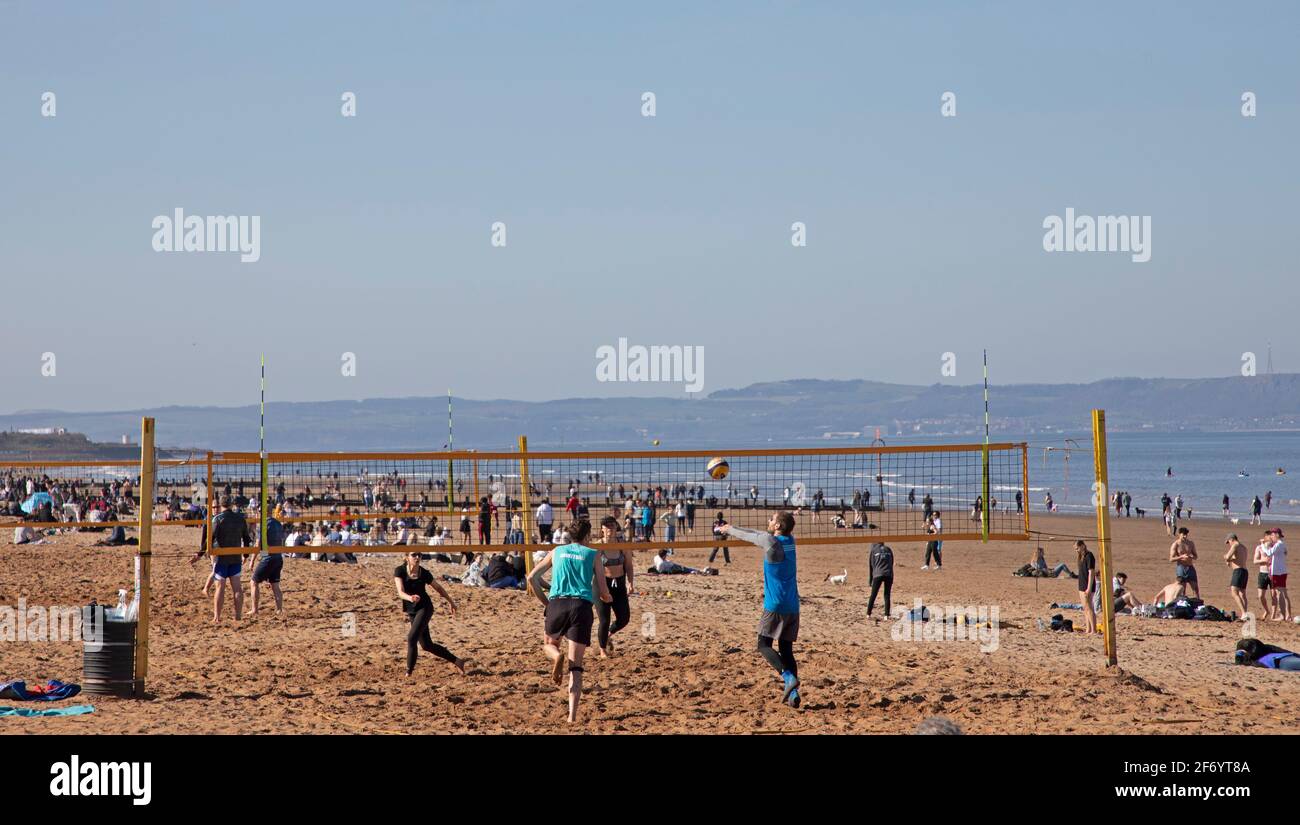 Portobello, Edinburgh, Scotland, UK weather. 3rd April 2021.Busy Easter Saturday for this first weekend of the 'Stay Local restriction' as the sunshine brought the crowds out at the seaside, temperature around 13 degrees. Pictured: Volleyball activity for these active young people. Stock Photo